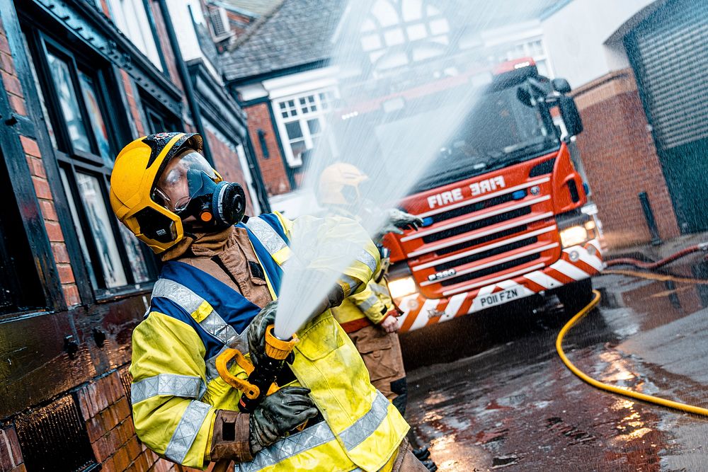 Firefighter using water hose, January 3, 2020, Northwich, UK. Original public domain image from Flickr