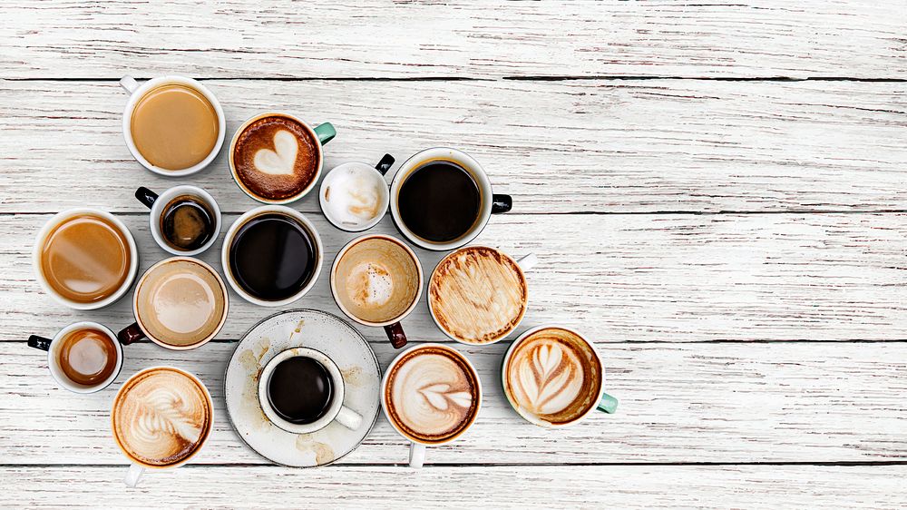 Coffee cups on a white rustic wooden textured background