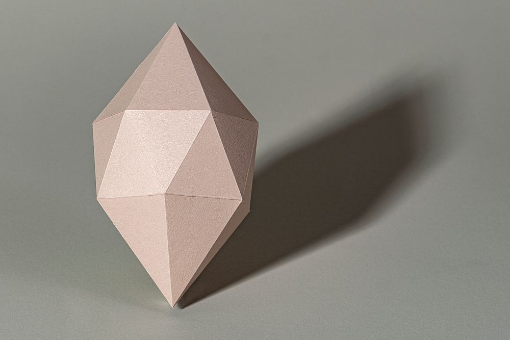 3D pink octahedral polyhedron shaped paper craft on a gray background