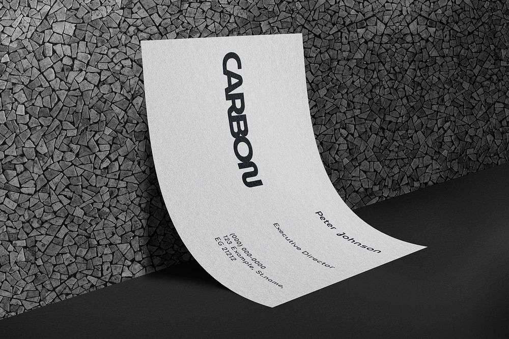 Carbon business card leaning on grunge wall