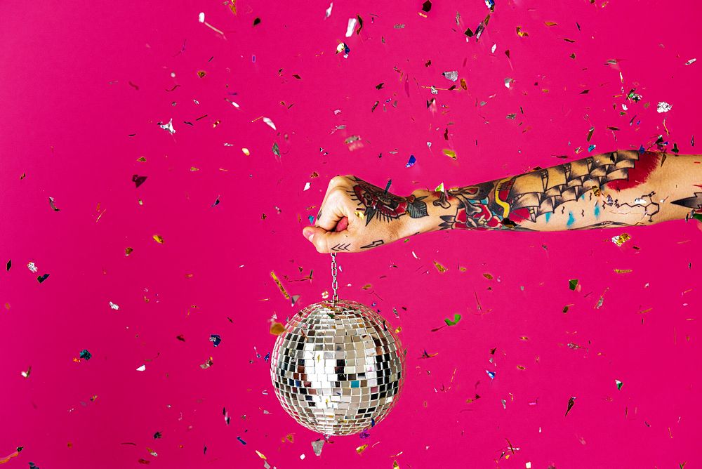 Party background, tattooed hand holding disco ball