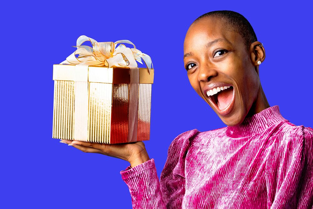 Happy black woman holding a gift box psd