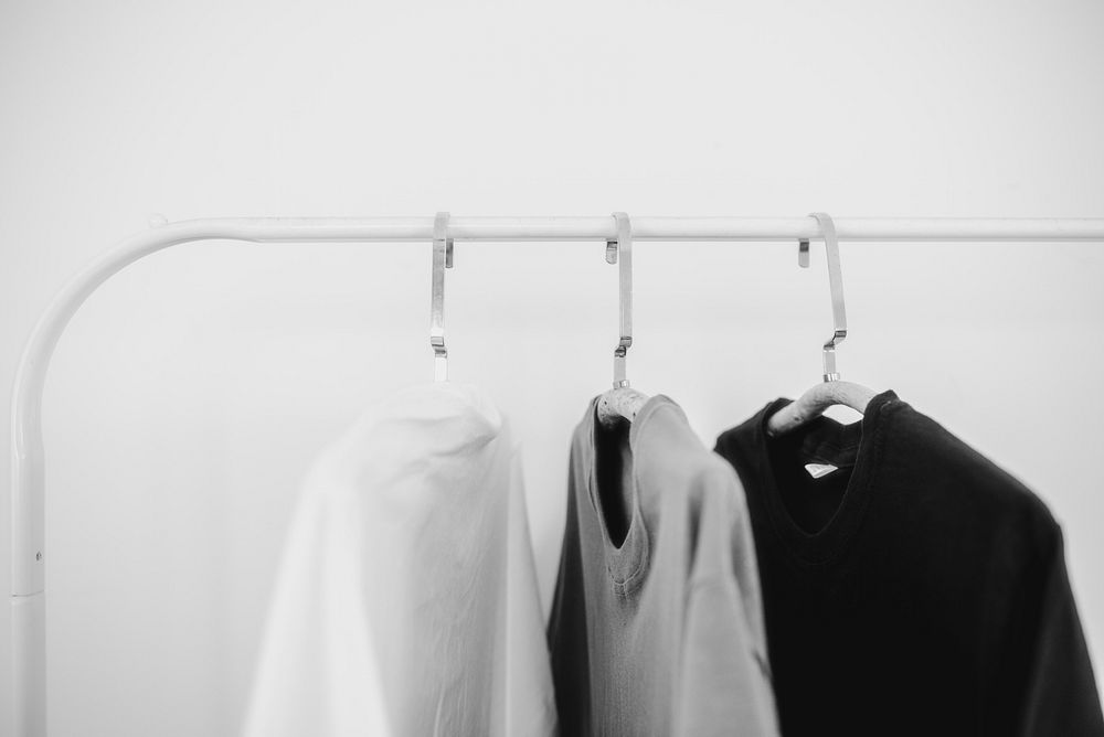 T-shirts on clothing rack, minimal gray photo