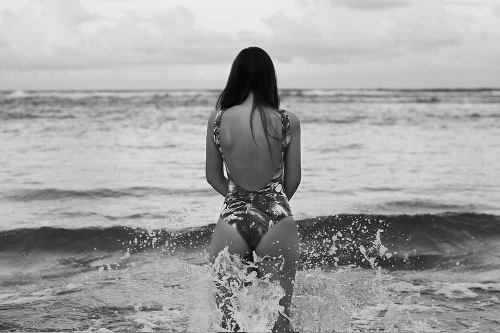 Woman wearing swimsuit at beach, gray photo