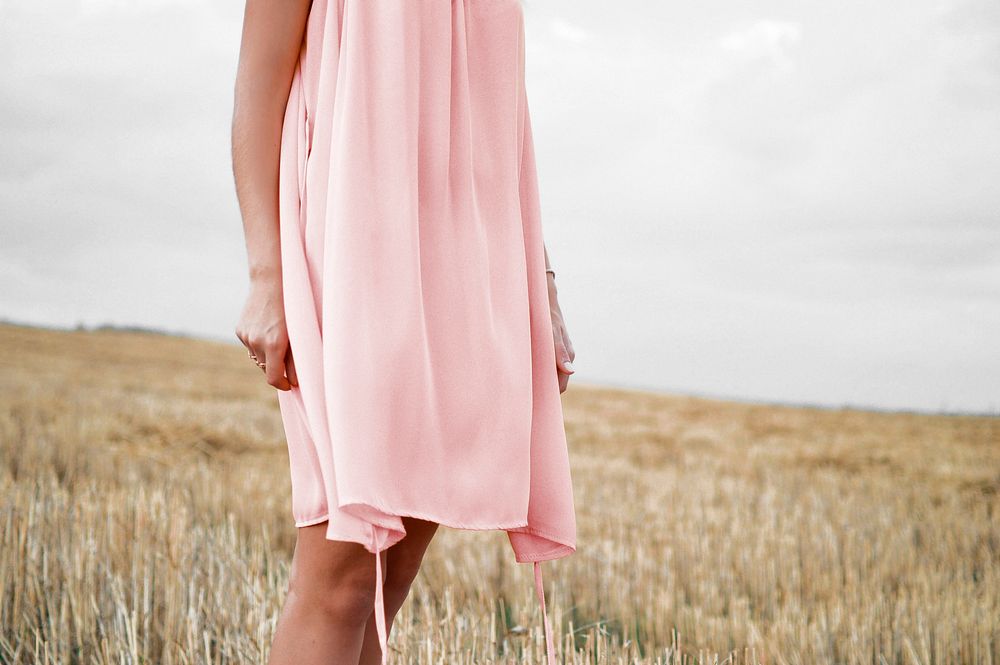 Woman in pink dress standing in the field