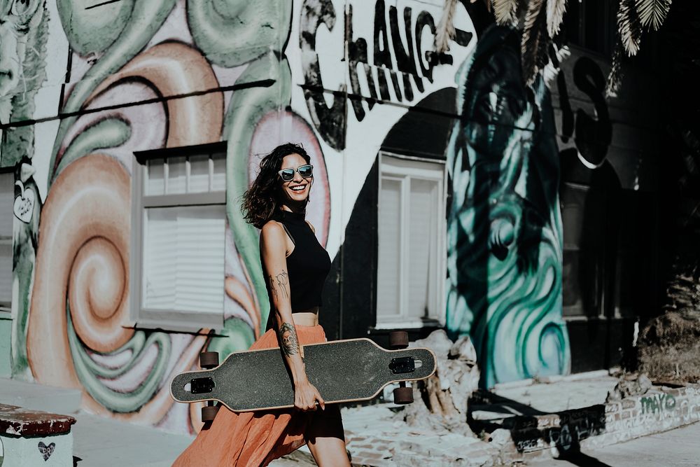 Woman carrying skateboard, Venice Beach, LA