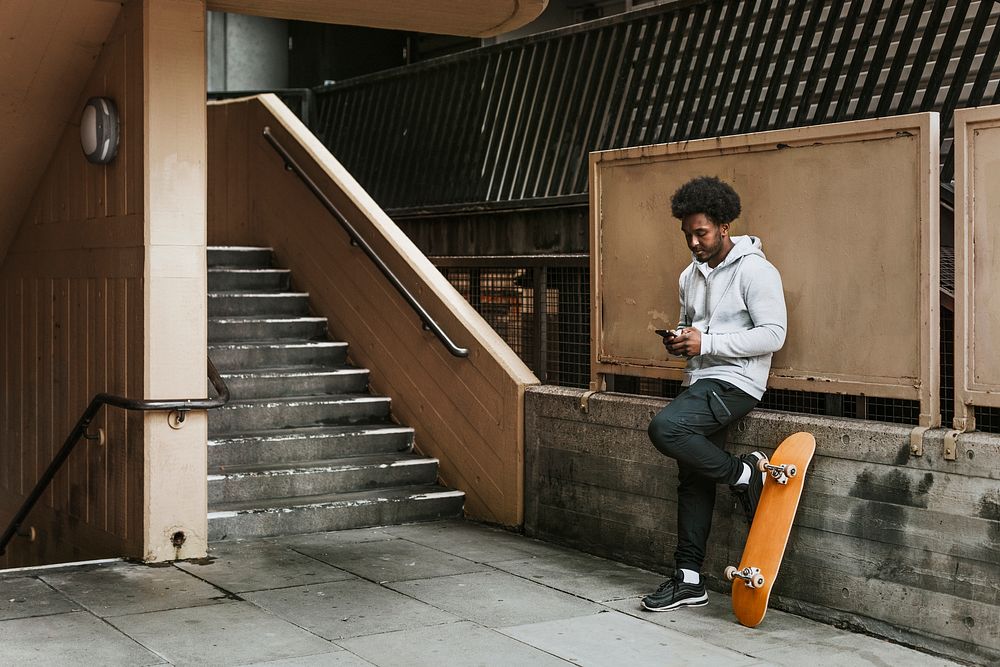 Skateboarder texting on his phone