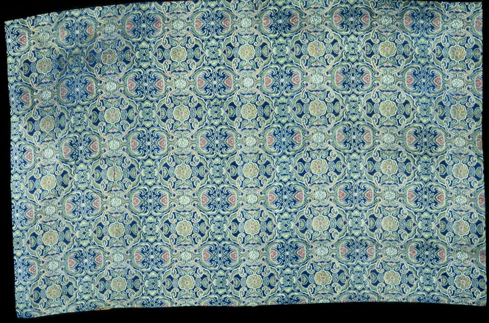 Panel of brocade with a diapered ground enriched with floral motifs. Colors chiefly blue and green, with pink, red, and…
