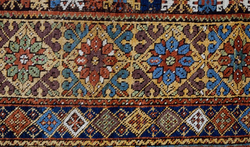 rug, prayer, with a red field fringed around the inner border with profile blossoms in dark blue. The prayer niche ahs a…