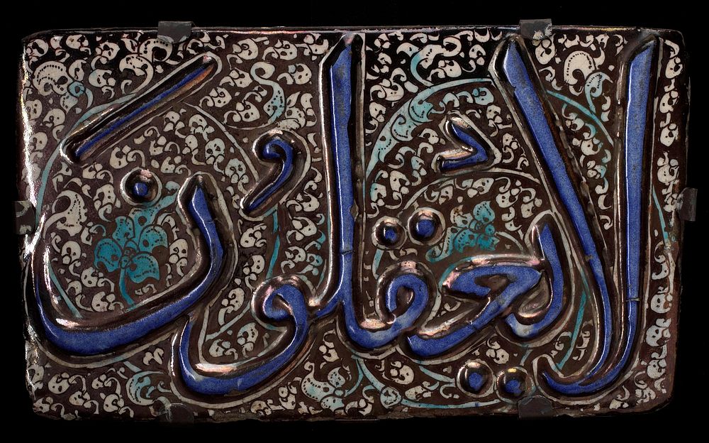 Tile, Sultanabad, pottery, with raised blue inscription on black and white floral background.. Original from the Minneapolis…