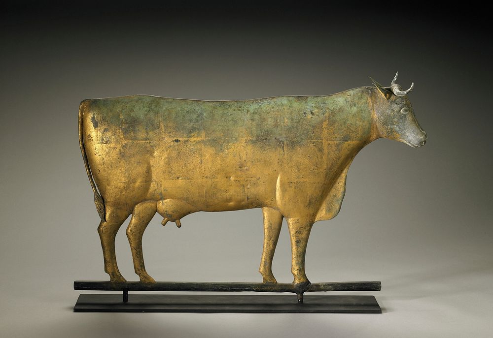 slightly rounded body with fully three-dimensional head; short horns; udder with two teats; gold, green and grey patina.…