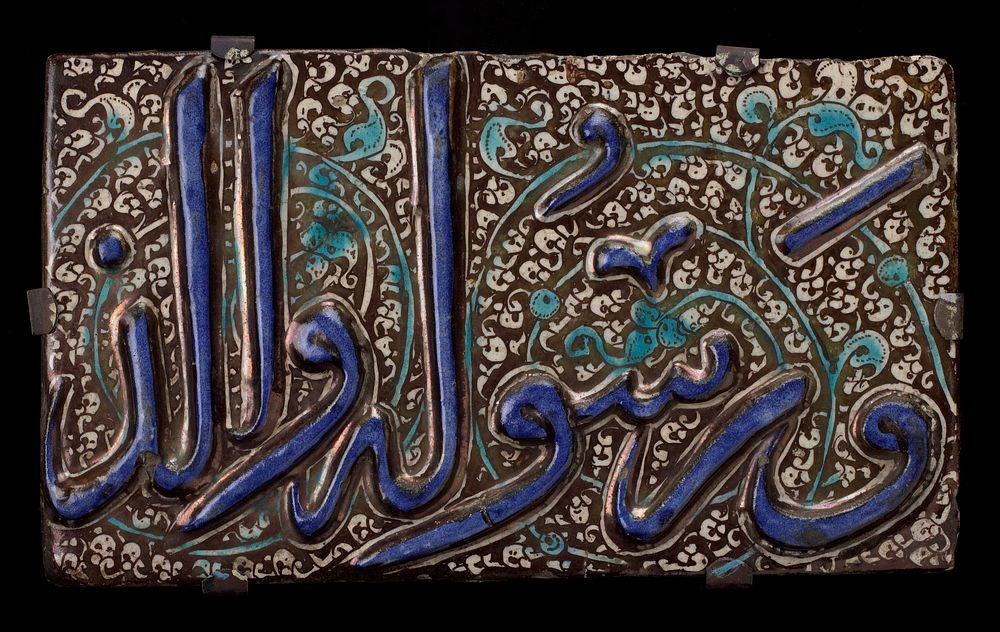 Tile, Sultanabad, pottery, raised blue inscription on black and white floral background.. Original from the Minneapolis…