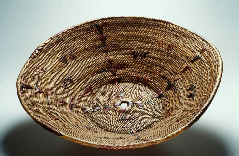 Large basket, quarter size hole in center; decoration includes triangle shaped pattern to form "x" shape in center; brown…