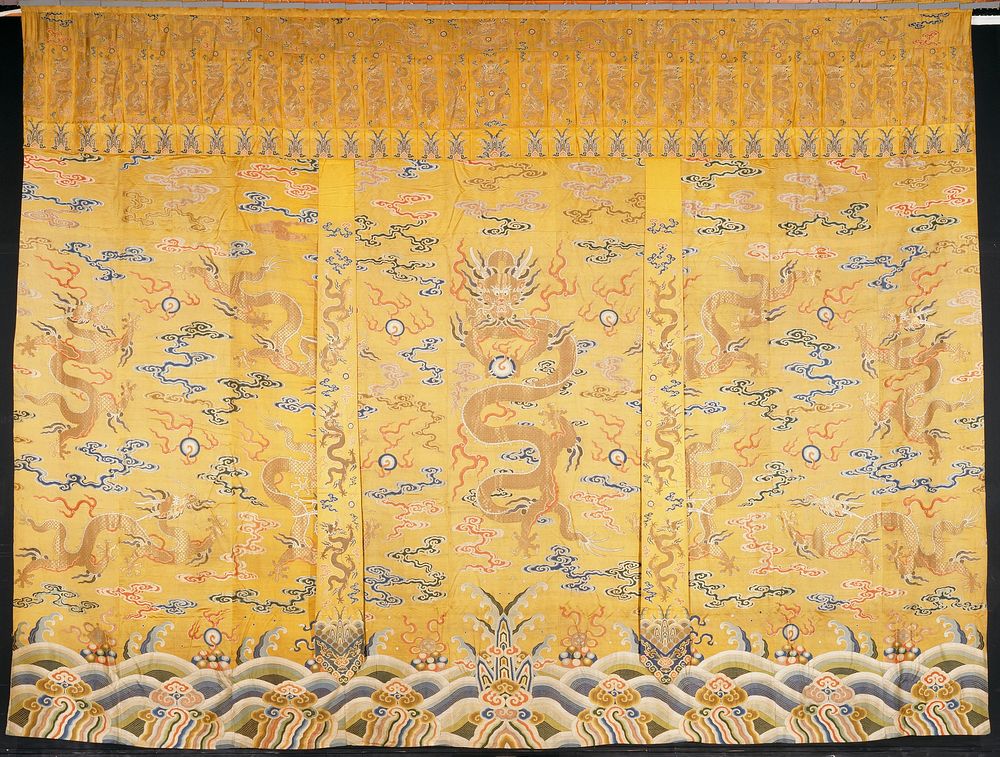 Large curtain hanging of imperial yellow brocaded satin. Design of nine large five-clawed dragons in gold in a field of…