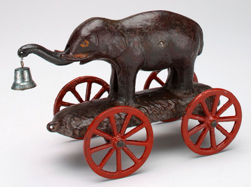 small elephant holding blue bell with its trunk; stands on platform with red wheels. Original from the Minneapolis Institute…
