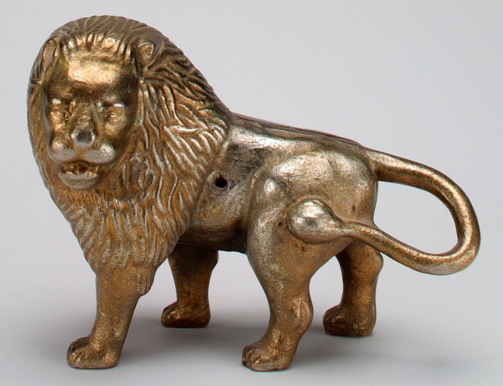 brass plated standing lion with head turned all the way to the left; tail wrapped around to attach at PL side; coin slot…
