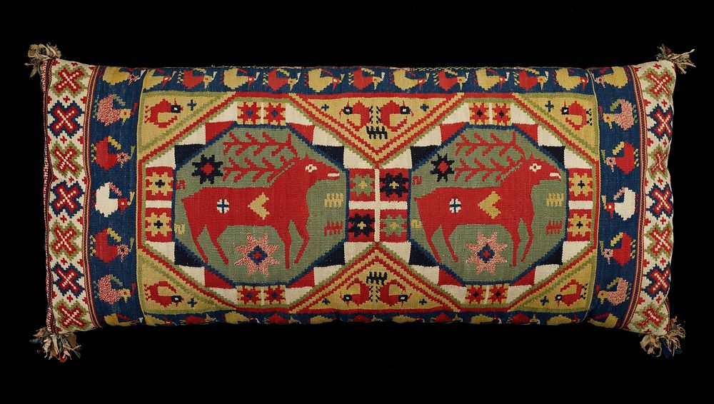 long pillow with tapestry woven cover; brightly colored with geometric designs, birds and deer on top; underside has bands…