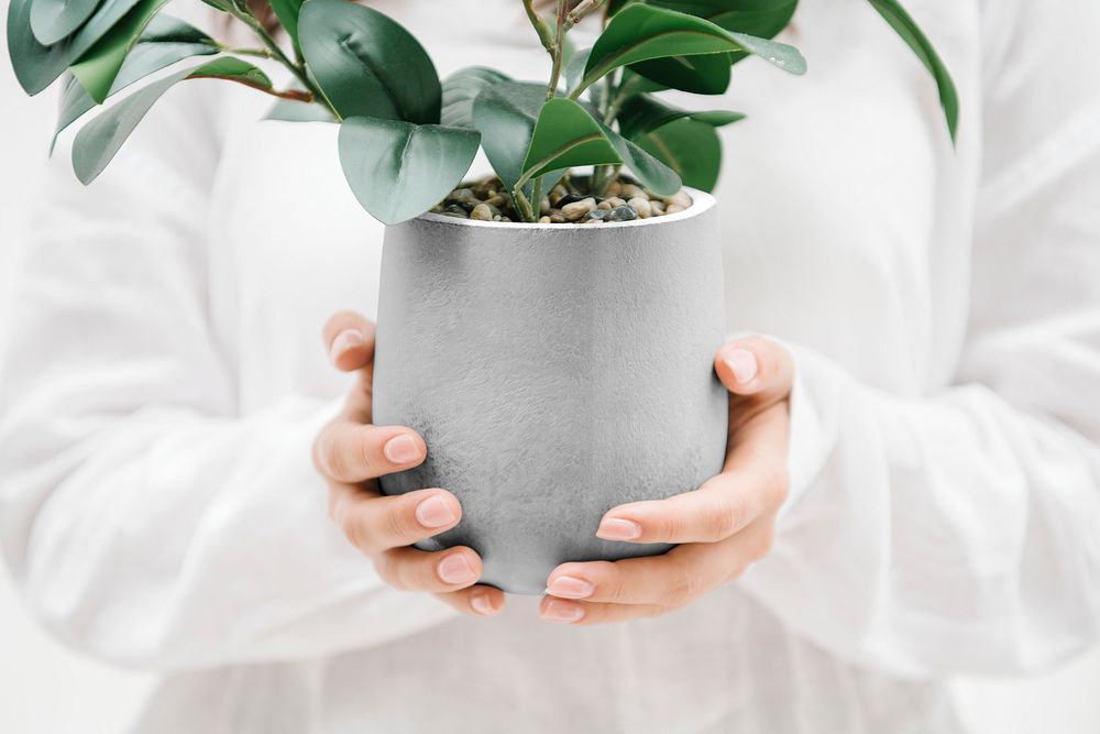 Woman holding a gray plant pot mockup