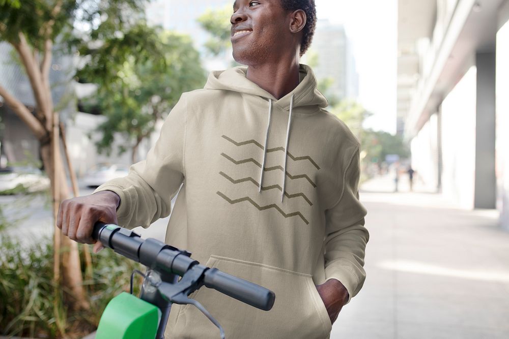 Man wearing hoodie, riding scooter 