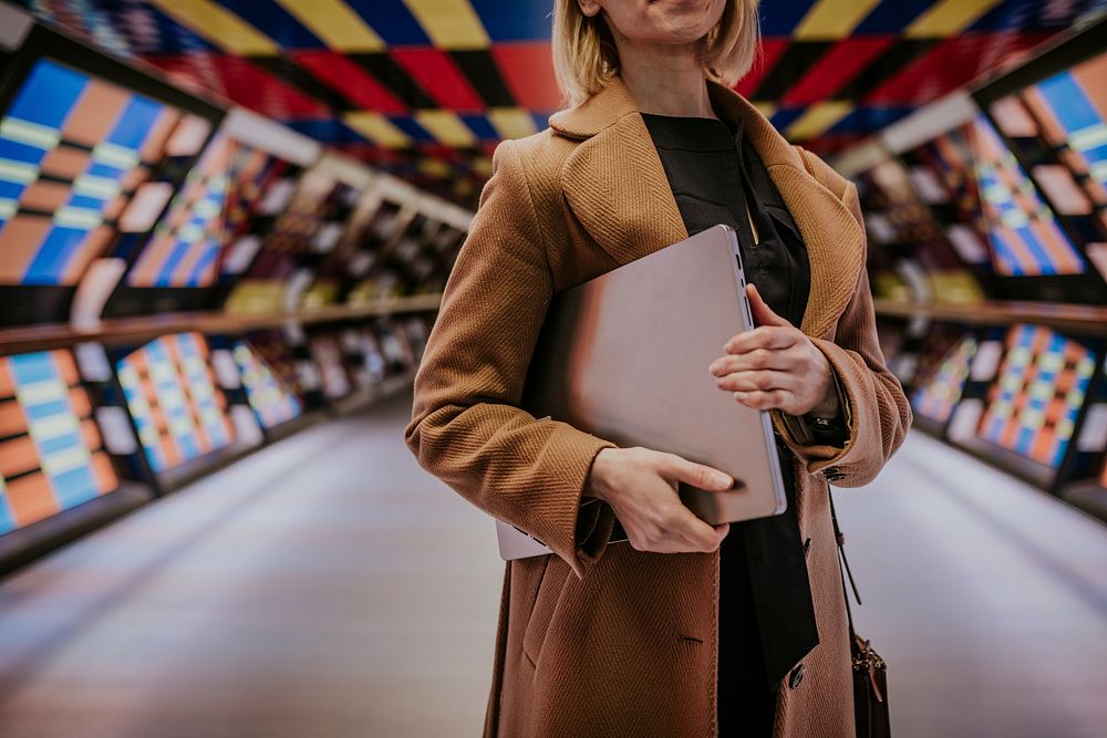 Businesswoman holding laptop, work essential