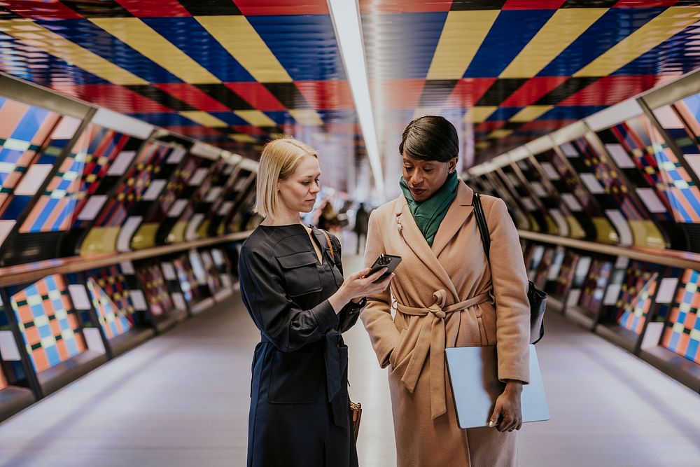 Businesswomen chatting, holding her phone