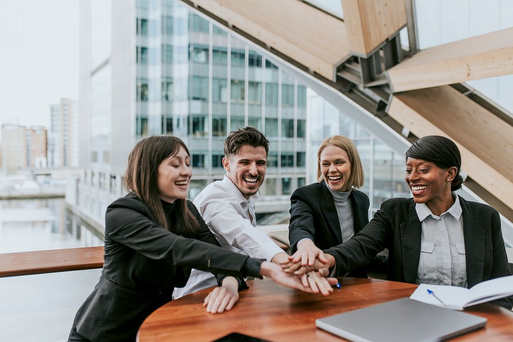 Diverse happy business people joining hands