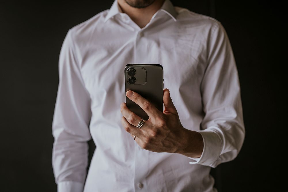 Businessman holding smartphone, digital device photo