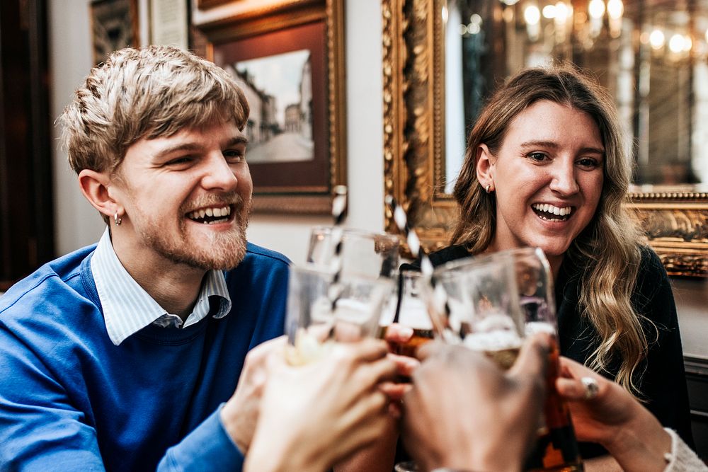 Happy people enjoying drinks in pub