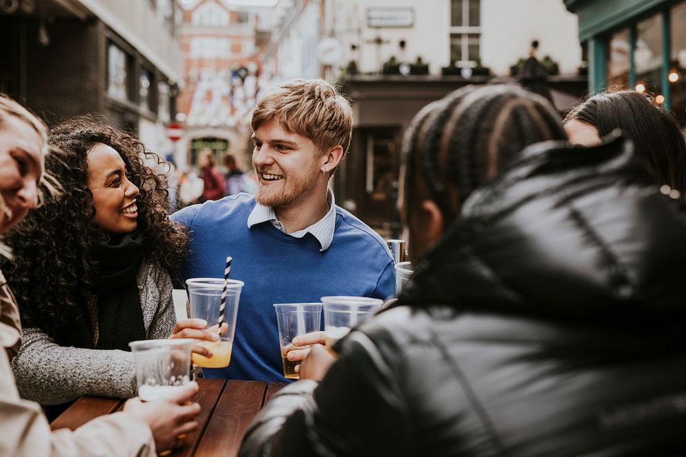 Diverse friends celebrating in pub, drinking beer