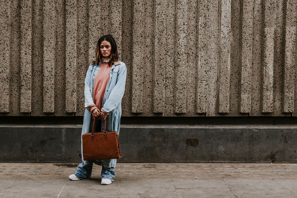 Woman holding brown leather bag