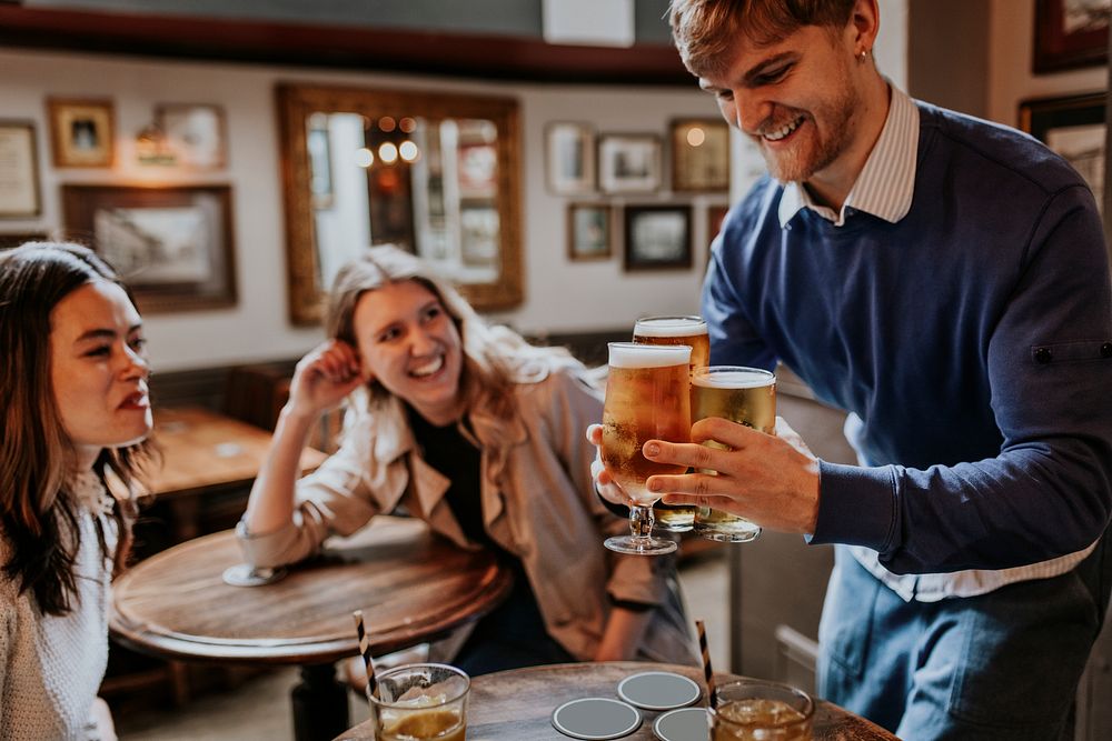 Man getting drinks for friends at a pub