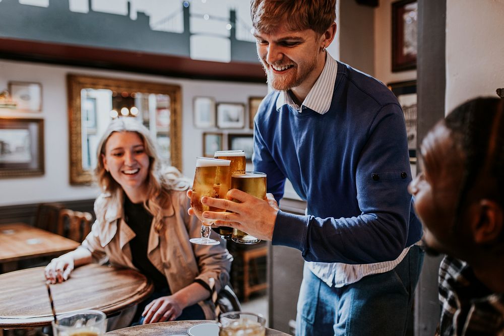 Man getting drinks for friends at a pub