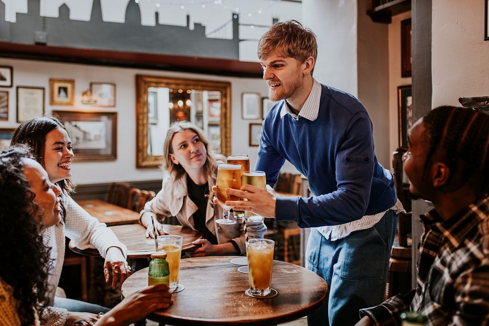 Man getting drinks for friends at a pub