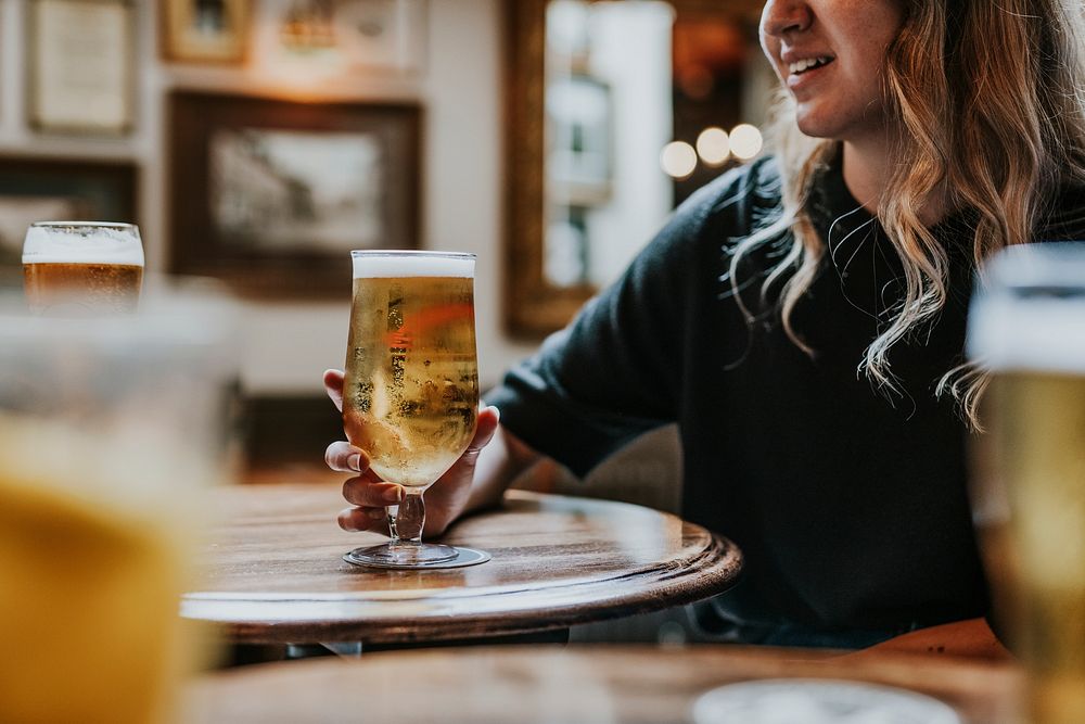 Woman sitting with beer glass in a pub