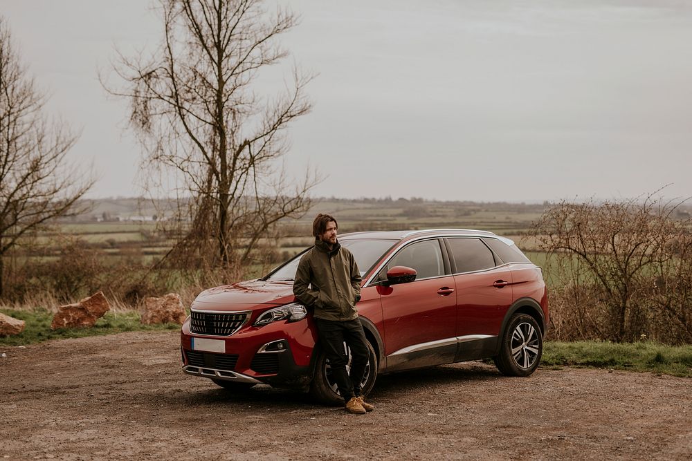 Man on road trip, leaning on car photo