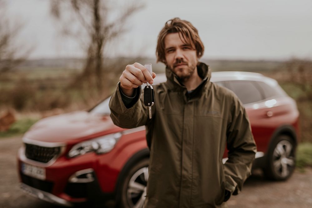 Man on road trip, showing car key photo