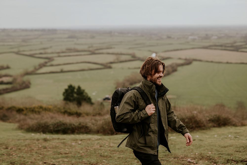 Smiling male hiker walking on hill