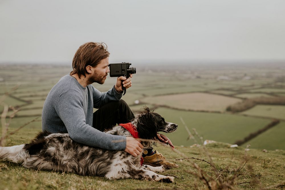 Man & dog sitting on hill photo