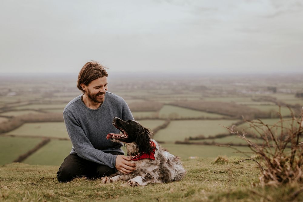 man-dog-sitting-on-hill-premium-photo-rawpixel