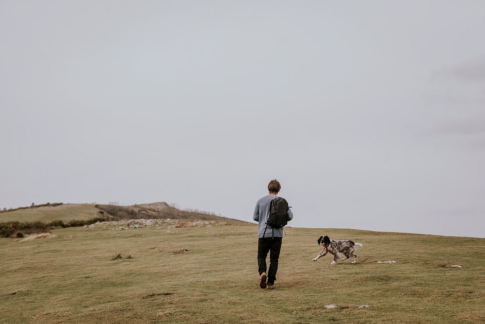 Man walking dog on hill photo