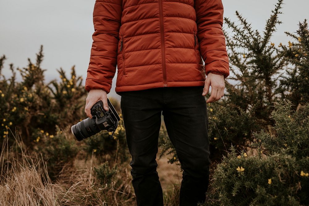 Photographer wearing jacket, holding camera, nature photo