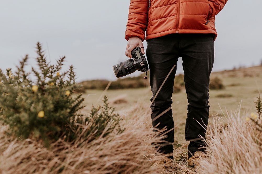 Photographer wearing jacket, holding camera, nature photo