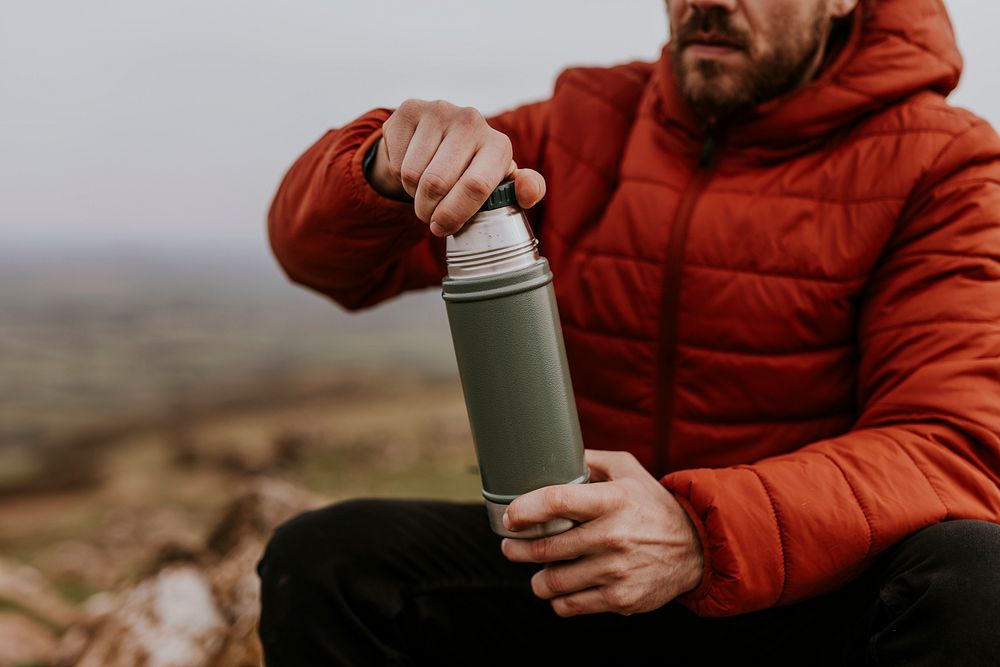Drinking coffee from a thermos, while hiking
