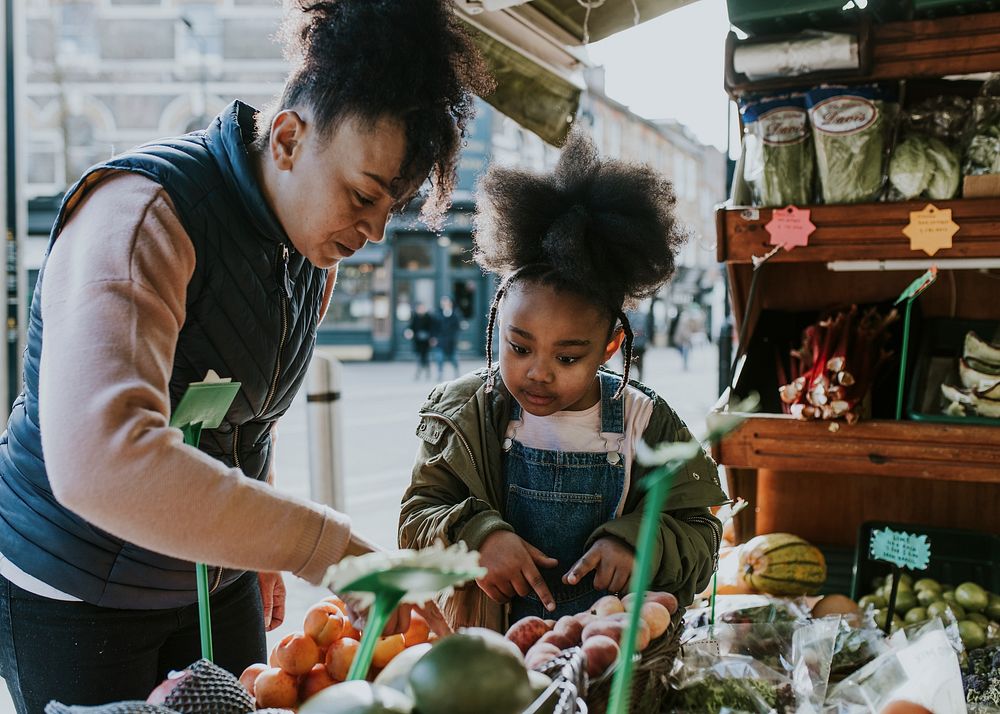 Mother and daughter picking vegetable at fresh market