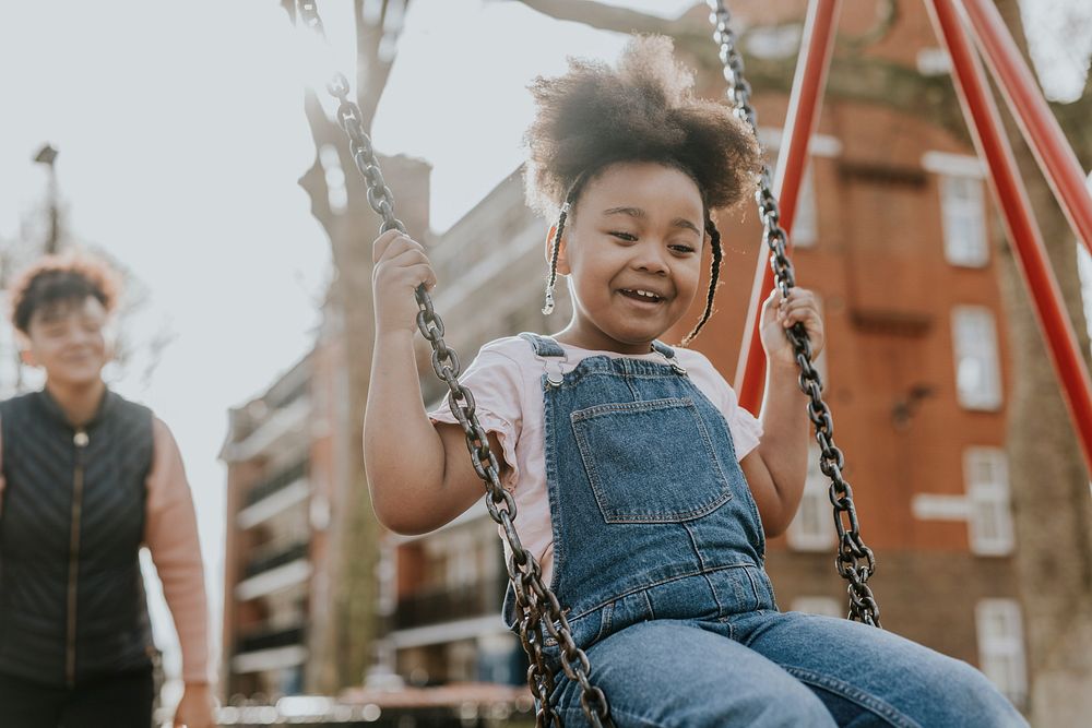 Happy girl sitting on swing