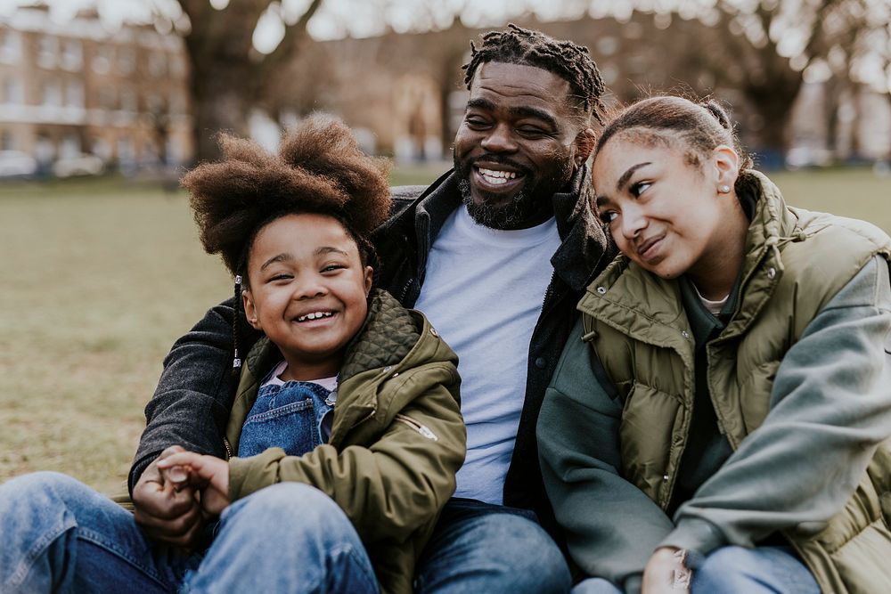 Happy black family sitting in a park