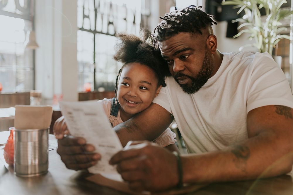 Dad and daughter looking at menu