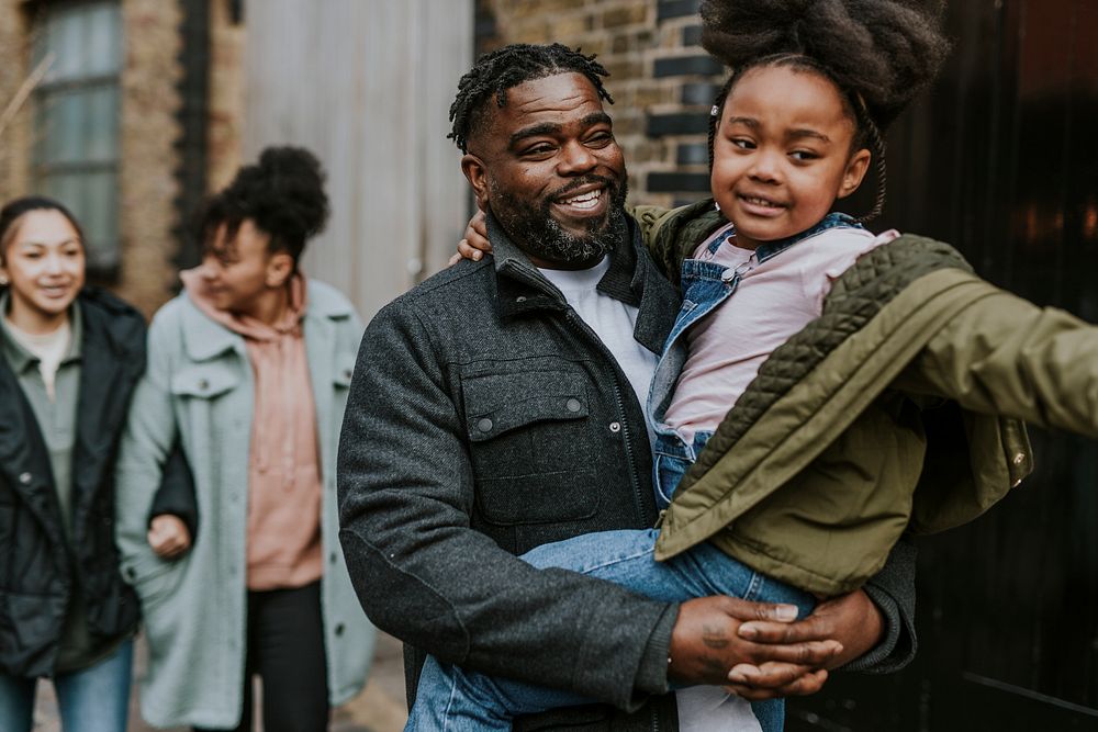 Dad carrying his daughter, walking in the city