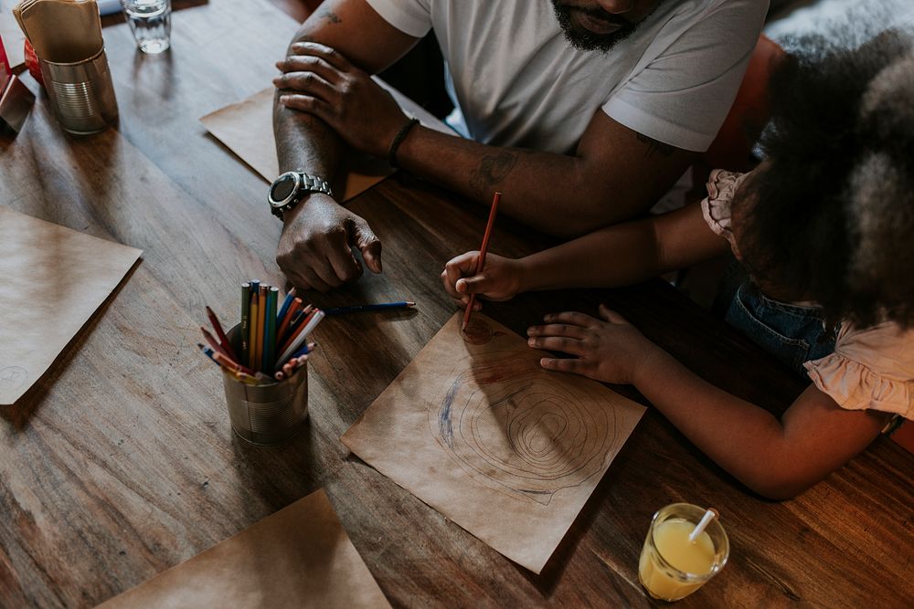 Daughter drawing with dad at a restaurant