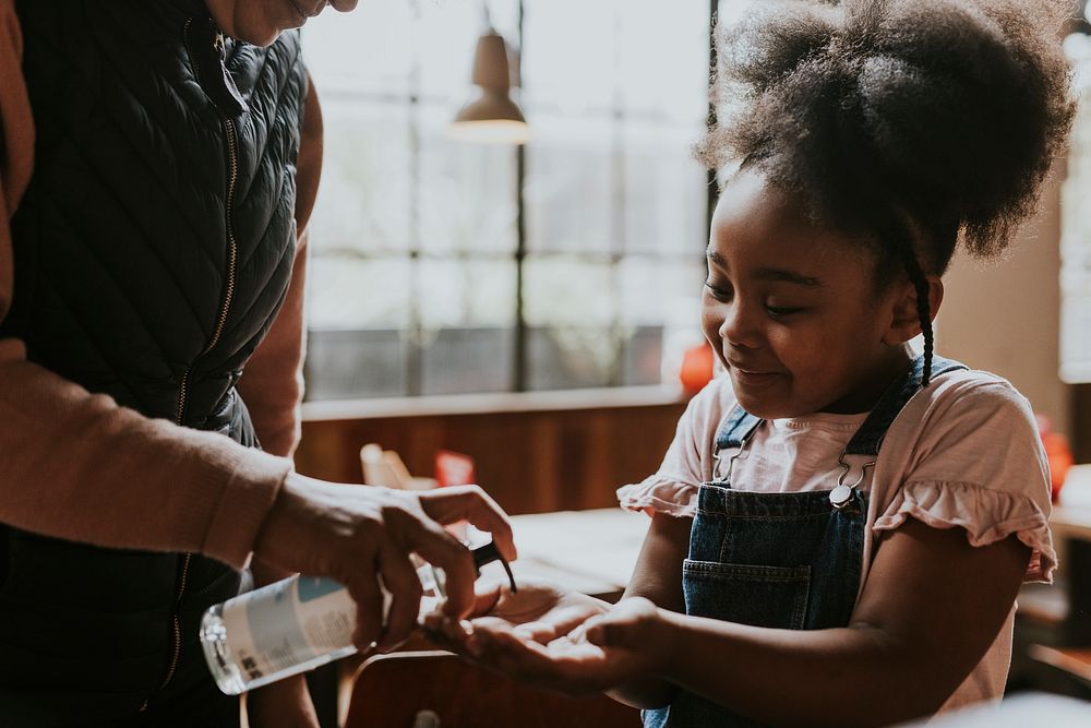 Little girl getting hand sanitizer